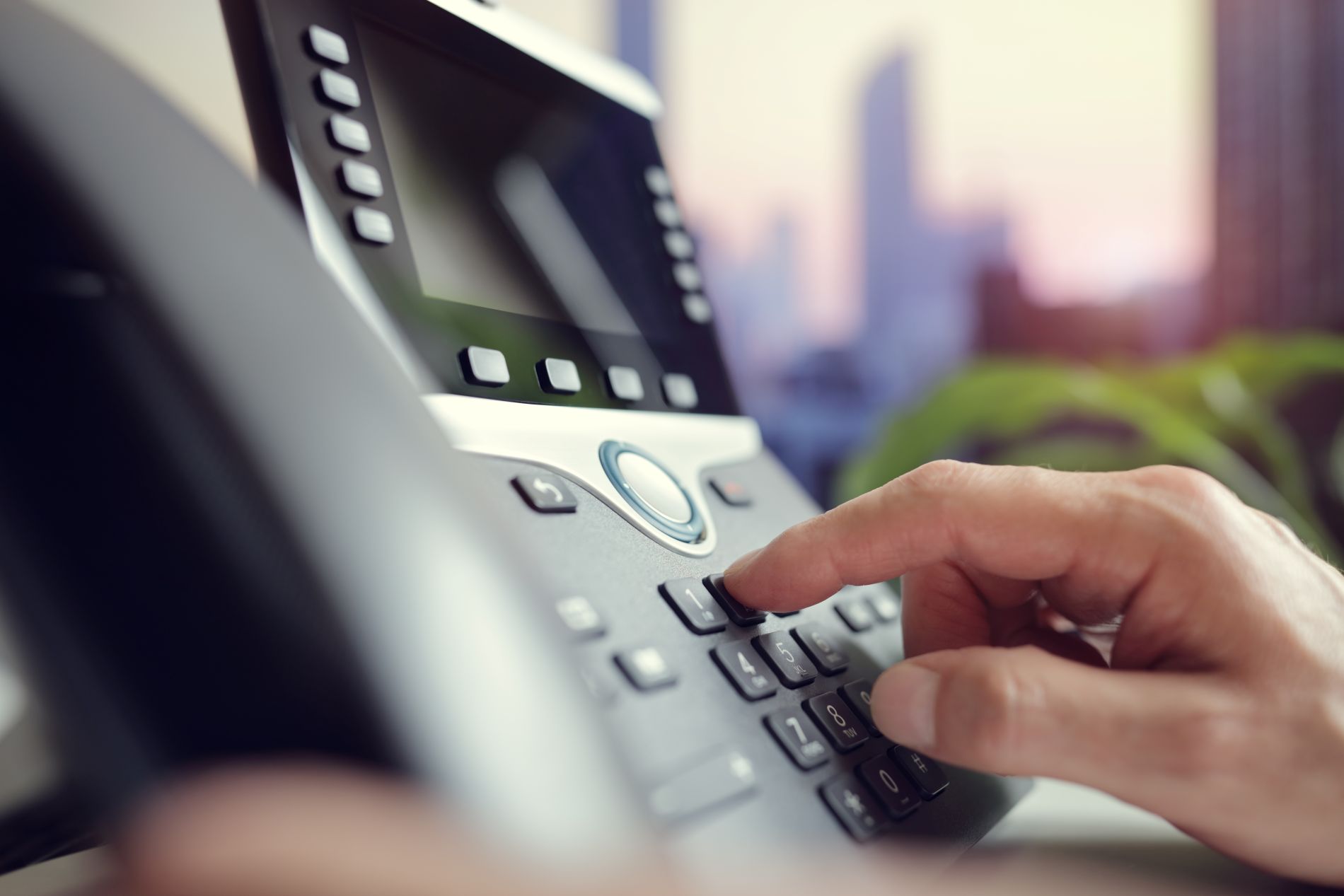 Persona marcando teclas en un teléfono Persona marcando teclas en un teléfono